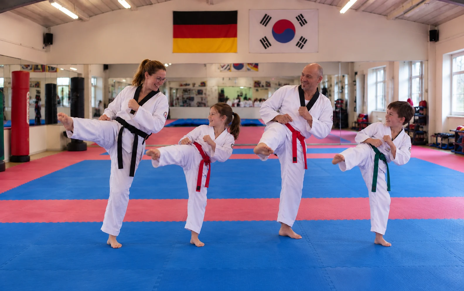Erwachsene und Kinder trainieren gemeinsam mit Freude Taekwondo
